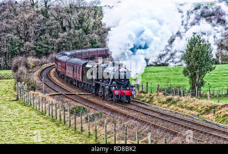 La Westcoast ferrovie Santa Offerte [nostalgia] treno a vapore che viene tirata da LMS Classe 8F 48151 avvicinamento stazione Wennington nel nord-ovest del Lancashire Foto Stock