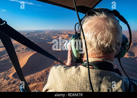 Uomo di fotografare da elicottero sopra Namib-Naukluft National Park, Namibia, Africa Foto Stock