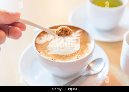 Aggiungere lo zucchero di caffè caldo Foto Stock