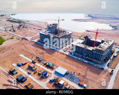 Vista aerea della costruzione di una gru a torre. Vista superiore gru e costruire il progresso di lavoro. Lavoratore. Sito in costruzione vista da fuco. Antenna vista superiore un Ne Foto Stock