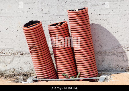 Rosso Arancio guaina corrugata per cavi elettrici, su un immobile sito in costruzione Foto Stock