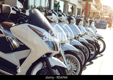 Noleggio vendita di motociclette Scooter. Un certo numero di motocicli per le strade della città. Foto Stock