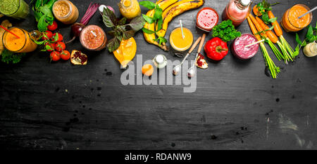 In estate i frullati di verdure, frutta e frutti di bosco. Su sfondo nero. Foto Stock