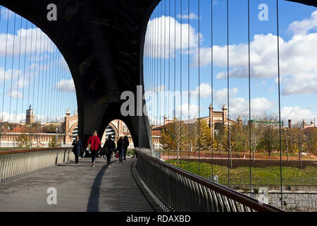 Madrid, Spagna - 23 Novembre 2018: la gente a piedi lungo il Matadero ponte sul fiume Manzanares. In background Matadero Madrid centro culturale. Argan Foto Stock