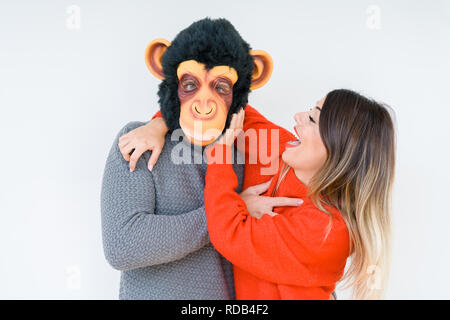 Divertente coppia giovane, ragazzo che indossa la maschera di scimmia, pazzo idiota e rapporto di amore Foto Stock