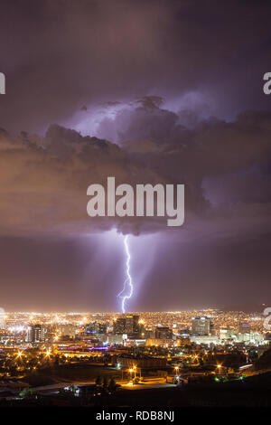 Il fulmine colpisce il paesaggio urbano dietro il centro di El Paso, Texas skyline in una calda notte d'estate vicino a noi a bordo del Messico Foto Stock