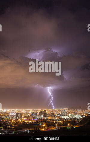 Il fulmine colpisce il paesaggio urbano dietro il centro di El Paso, Texas skyline in una calda notte d'estate vicino a noi a bordo del Messico Foto Stock