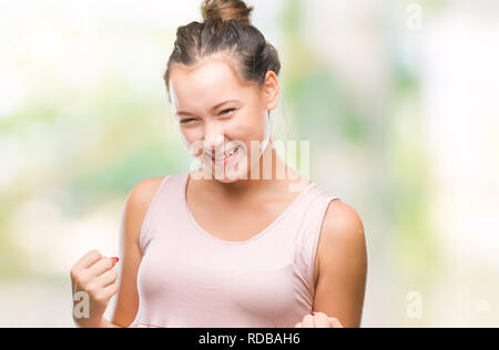 Giovani caucasici bella donna su sfondo isolato molto felici ed eccitati facendo vincitore gesto con le braccia sollevate, sorridente e urlando per succe Foto Stock