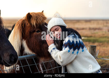 Donna cuddling con adorabile cavallo islandese su Islanda viaggio su strada Foto Stock