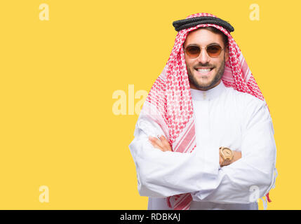 Giovane uomo bello indossare keffiyeh su sfondo isolato buon viso sorridente con bracci incrociati guardando la telecamera. Persona positiva. Foto Stock