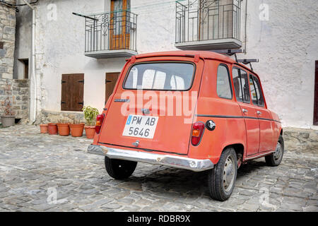 Un tradizionale vecchio Renault 4 TL red auto parcheggiate nella piazza di pietra del mondo rurale città di montagna di Ansó, nei Pirenei Aragonesi Foto Stock