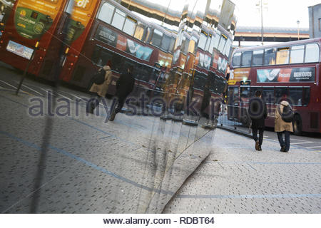 Passaggio di un bus è riflessa in una finestra di vetro a Birmingham in Inghilterra su un inverno di pomeriggio. Foto Stock
