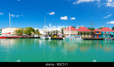 St Johns, Antigua - Marzo 05, 2016: quay con case e barche in mare turchese sul cielo blu. Viaggiare e wanderlust. Vacanze estive sull isola tropicale. Foto Stock