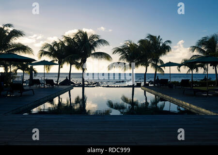 Piscina a sfioro di resort in Mauritius durante il tramonto Foto Stock