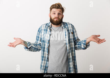 Confuso giovane uomo vestito di plaid shirt in piedi isolato su sfondo bianco Foto Stock