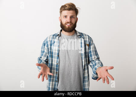 Confuso giovane uomo vestito di plaid shirt in piedi isolato su sfondo bianco Foto Stock