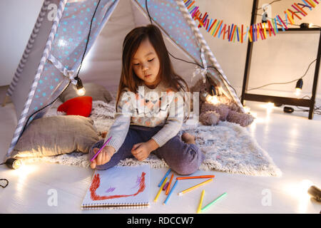 Felice giovani asiatici bambina divertirsi sul pavimento. Disegno. Concetto di natale Foto Stock