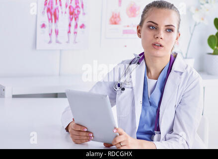 Un giovane medico donna a una scrivania in ufficio. Il concetto di h Foto Stock