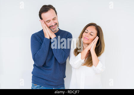 Bella la mezza età matura in amore su sfondo isolato dormire stanchi di sognare e in posa con le mani insieme mentre sorridente con gli occhi chiusi. Foto Stock