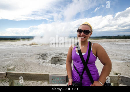 I giovani adulti turista femminile si erge nei pressi di spasmo Geyser nel Parco Nazionale di Yellowstone Foto Stock