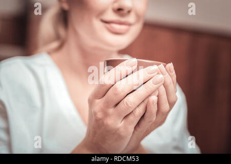 Close up di mani femminili tenendo la coppa Foto Stock