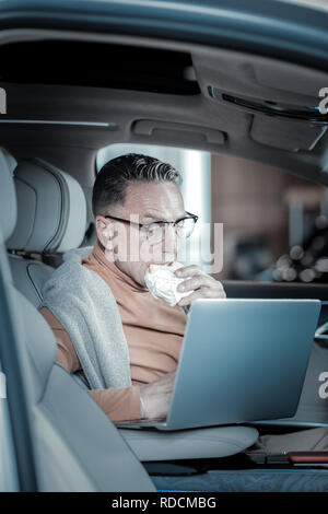 Imprenditore prepara per sale lettura di documenti sul computer portatile Foto Stock
