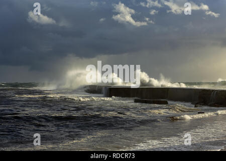 Mare tempestoso onde di oltre il molo e il faro con bella luce prima pioggia. Ave foce, a Vila do Conde, il nord del Portogallo. Foto Stock