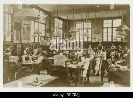 Cartolina edoardiana originale dei primi anni '1900 degli scolari edoardiani che disegnano piani per la lavorazione del legno in una classe, intorno al 1910, Regno Unito Foto Stock