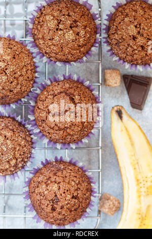 Muffin al cioccolato con banana e crosta di zucchero sulla griglia di cottura. Freschi dolci fatti in casa. Messa a fuoco selettiva, vista dall'alto Foto Stock