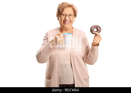 Allegra donna senior con una ciambella di cioccolato e una tazza di caffè isolato su sfondo bianco Foto Stock