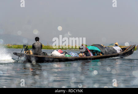 Gruppo di persone locali utilizzando i mezzi di trasporto sul Lago Inle viaggiando su una barca dalla lunga coda di fronte Lago Inle, Stato Shan, Myanmar (Birmania) Foto Stock