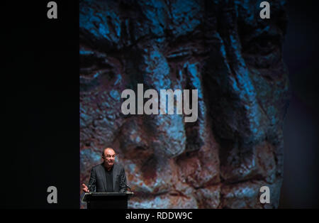 18 gennaio 2019, Renania-Palatinato, Mainz: Robert Menasse, scrittore austriaco e vincitore del 2019 Carl Zuckmayer medaglia, darà un discorso di ringraziamento presso lo Staatstheater. Sullo sfondo è possibile vedere un dettaglio proiezione del busto Carl-Zuckmayer in piedi in Nackenheim. La medaglia è donato in memoria dello scrittore e drammaturgo che era nato a Nackenheim. Il premio riconosce i meriti per la lingua tedesca ed è presentato annualmente. Foto: Andreas Arnold/dpa Foto Stock