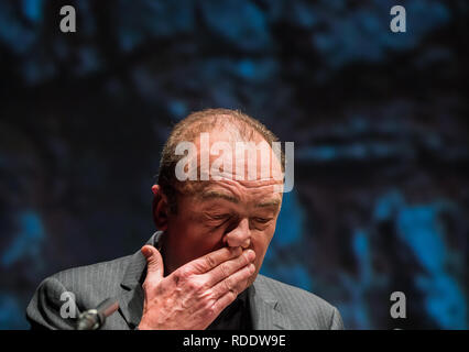 18 gennaio 2019, Renania-Palatinato, Mainz: Robert Menasse, scrittore austriaco e vincitore del 2019 Carl Zuckmayer medaglia, darà un discorso di ringraziamento presso lo Staatstheater. Sullo sfondo è possibile vedere un dettaglio proiezione del busto Carl-Zuckmayer in piedi in Nackenheim. La medaglia è donato in memoria dello scrittore e drammaturgo che era nato a Nackenheim. Il premio riconosce i meriti per la lingua tedesca ed è presentato annualmente. Foto: Andreas Arnold/dpa Foto Stock