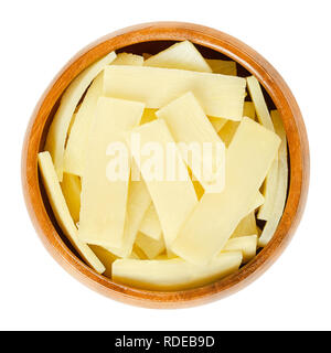 Germogli di bambù in ciotola di legno. Conserve di fette di germogli di bambù, utilizzato come vegetale in piatti asiatici. Isolate il cibo macro photo closeup dal di sopra. Foto Stock