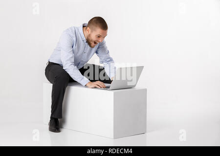 Giovane uomo bello in camicia e cravatta con laptop Foto Stock