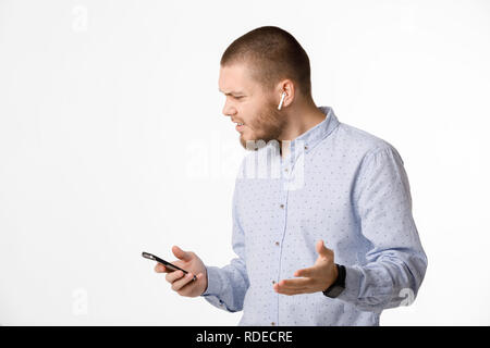 Imprenditore barbuto utilizza le cuffie wireless dello smartphone e Foto Stock