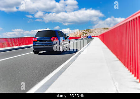 Un car guida attraverso un bel ponte su un giorno d'estate. Foto Stock