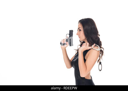 Elegante security agent in abito nero azienda pistola e manette, isolato su bianco Foto Stock