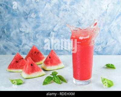 Appetitosi gustosi drink di anguria con basilico in vetro grigio sul tavolo. In casa di anguria e basilico limonata con spruzzi. Copia dello spazio. Waterm Slice Foto Stock