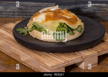 Vegan hamburger con formaggio e ketchup sul nero piatto in legno Foto Stock