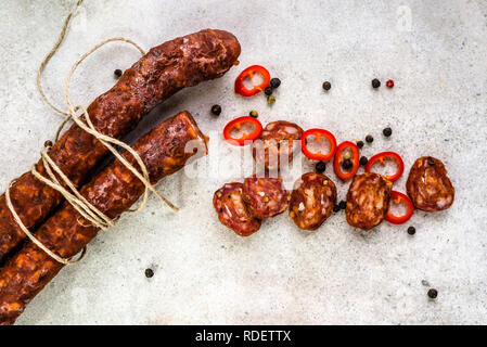 Il cibo dalla Spagna, il salame chorizo fette di salame o salsiccia per pizza, tradizionali tapas spagnoli, overhead. Foto Stock