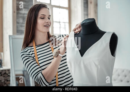 Talentuoso dark-donna dai capelli bianchi di cucitura abiti lunghi Foto Stock