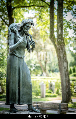 Gesù con la scultura di agnello al Nordfriedhof a Monaco di Baviera Foto Stock