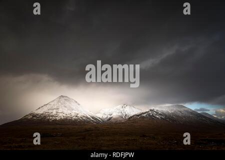 Moor paesaggio con cime innevate dei monti Cullins di fronte drammatico nuvole nel paesaggio delle highland, Sligachan Foto Stock