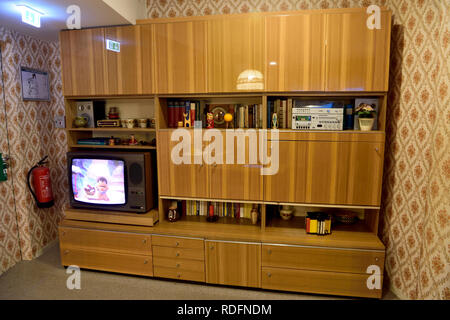Berlino, Germania - 10 novembre 2018. Tipico stile sovietico credenza sul display a DDR Museum di Berlino, con Libro, TV e negozio di souvenir. Foto Stock