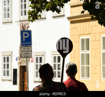 Praga, Repubblica ceca - Agosto 2018: Silhouette di una guida turistica a Praga tenendo in mano un cartello per il suo tour parte da seguire. Foto Stock