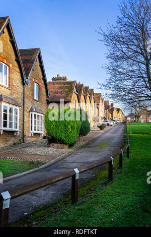 Prospettiva quadrato con i lavoratori di case costruite intorno al comune erbosa in Westbury, Wiltshire, Regno Unito il 17 gennaio 2019 Foto Stock