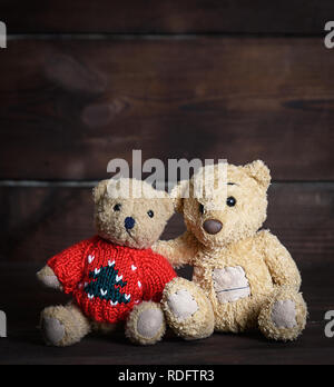 Due piccolo marrone morbidi orsacchiotti sono seduto su di una superficie di legno, close up Foto Stock