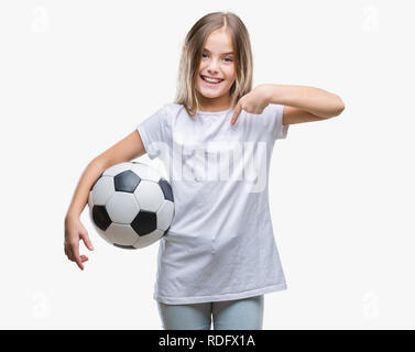 Giovane bella ragazza con soccer football palla su sfondo isolato con sorpresa faccia puntare il dito a se stesso Foto Stock