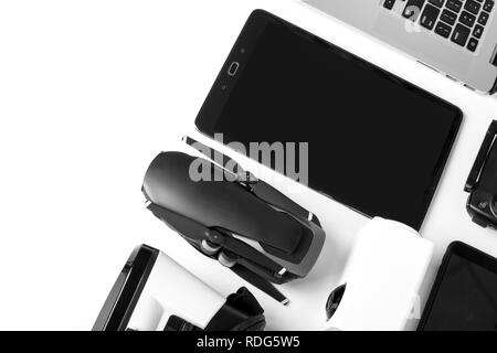 Gadget moderni su uno sfondo bianco, una pastiglia con una schermata scura accanto al fuco e il computer portatile Foto Stock